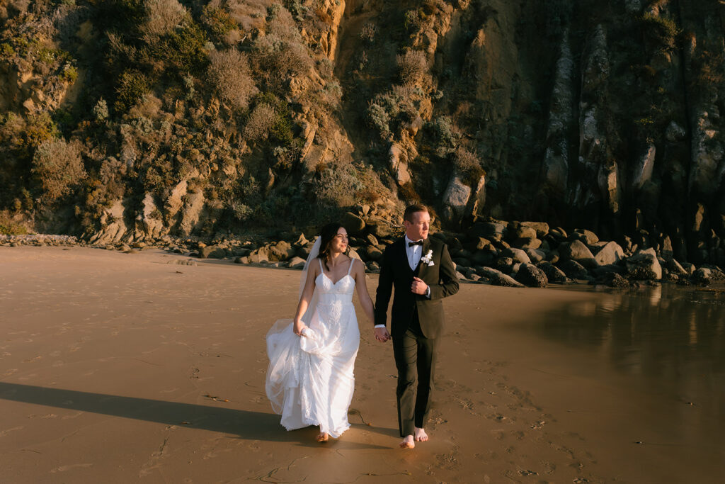 couple walking around the beach on their wedding day